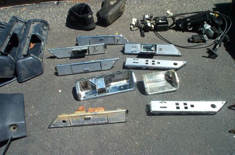 1991 Ford Crown Victoria LTD - Collection of automotive interior parts, including door handles and trim, scattered on the ground.