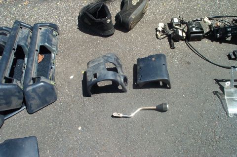 1991 Ford Crown Victoria LTD - Assorted car parts, possibly from a Ford Crown Victoria, are displayed on the ground.