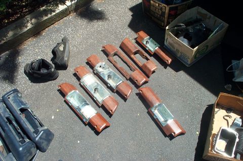 1991 Ford Crown Victoria LTD - Various car interior trim pieces are laid out on asphalt next to a pair of shoes and boxes.