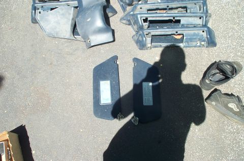 1991 Ford Crown Victoria LTD - Various interior car parts, including dashboard trim and sun visors, laid out on pavement.