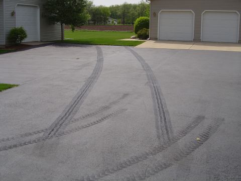 1978 Ford Bronco - Tire marks are visible on the asphalt driveway, indicating recent vehicle activity.