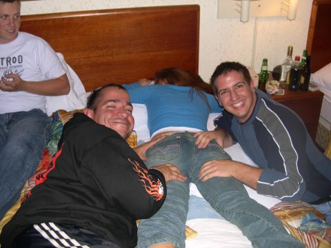 1997 Ford Probe - A group of friends are gathered in a hotel room, with two men posing on a bed next to a woman.