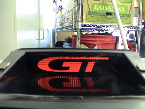 1997 Ford Probe - Close-up of a GT brake light, showing the red lettering and its reflection.