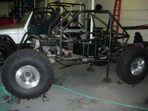 1995 Ford Bronco - Custom buggy frame and engine assembly in a workshop, with a Jeep visible.