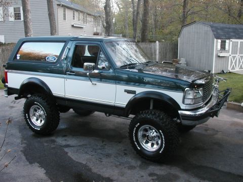 1994 Ford Bronco - This 1994 Ford Bronco features a two-tone paint scheme, an aftermarket bumper, and large off-road tires.