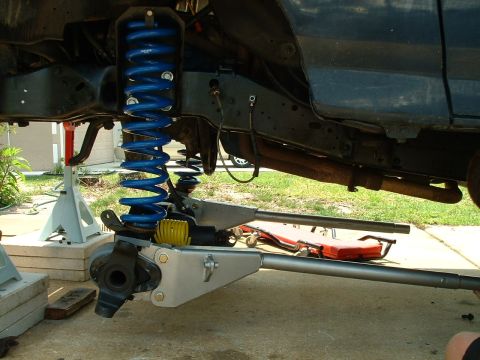 1995 Ford Bronco - Close-up of vehicle suspension system with blue coil springs and aftermarket components.