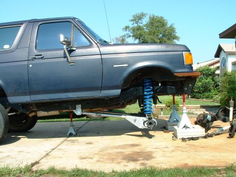 1995 Ford Bronco - A 1995 Ford Bronco is shown with its suspension components removed and the vehicle supported by jack stands.