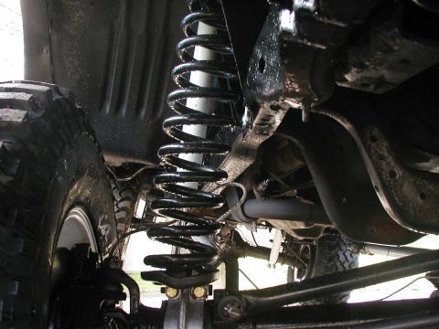 1994 Ford Bronco - Underside view of a vehicle's suspension system, showing the coil spring and shock absorber.