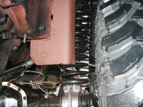 1994 Ford Bronco - A detailed view of a vehicle's undercarriage, focusing on the suspension system and a large tire.