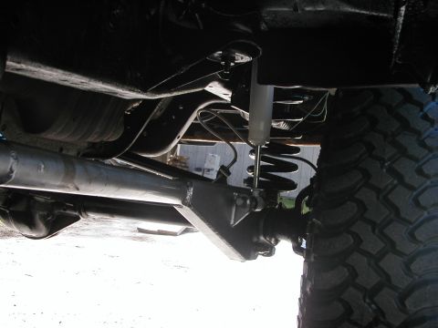 1994 Ford Bronco - Close-up of vehicle undercarriage, focusing on suspension components and tire.