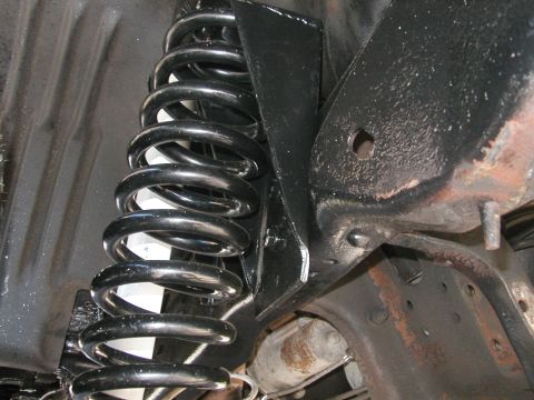 1994 Ford Bronco - Close-up view of a vehicle's suspension system, showing a coil spring and frame components.