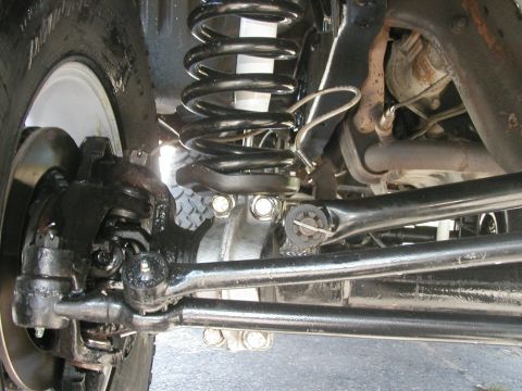1994 Ford Bronco - Close-up view of the front suspension and steering linkage of an SUV.