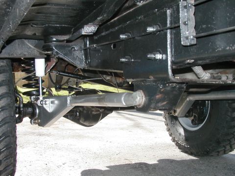 1994 Ford Bronco - Close-up of aftermarket suspension parts on a vehicle's undercarriage.
