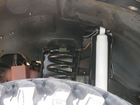 1994 Ford Bronco - The image shows the inner workings of a vehicle's suspension system, including a coil spring and shock absorber.