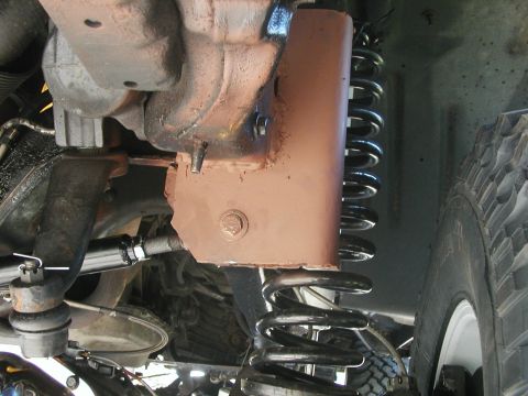 1994 Ford Bronco - Undercarriage view of a vehicle's suspension system with visible rust and a large coil spring.