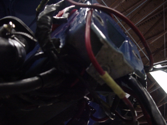 Close-up of blue plastic housing with red and yellow wires connected to an engine wiring harness