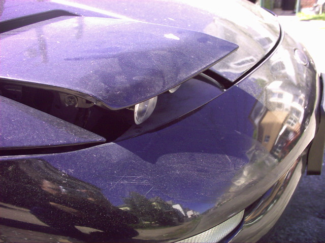 1997 Ford Probe front headlight assembly, pop-up headlight partially raised