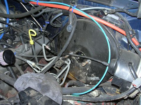 1991 Ford Bronco - Close-up view of the engine bay, focusing on the brake booster and associated plumbing.