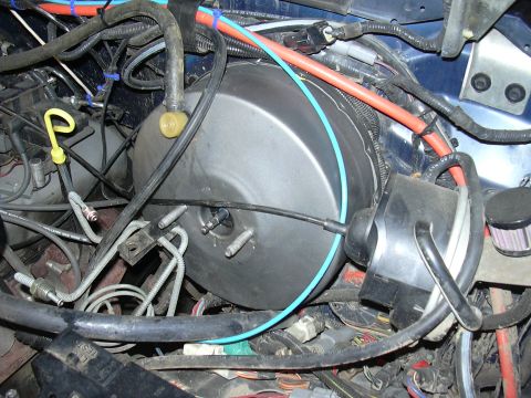 1991 Ford Bronco - Close-up view of engine bay components, including the brake booster and various hoses and wires.