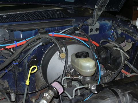 1991 Ford Bronco - Close-up of the brake booster and master cylinder assembly in a vehicle's engine bay.