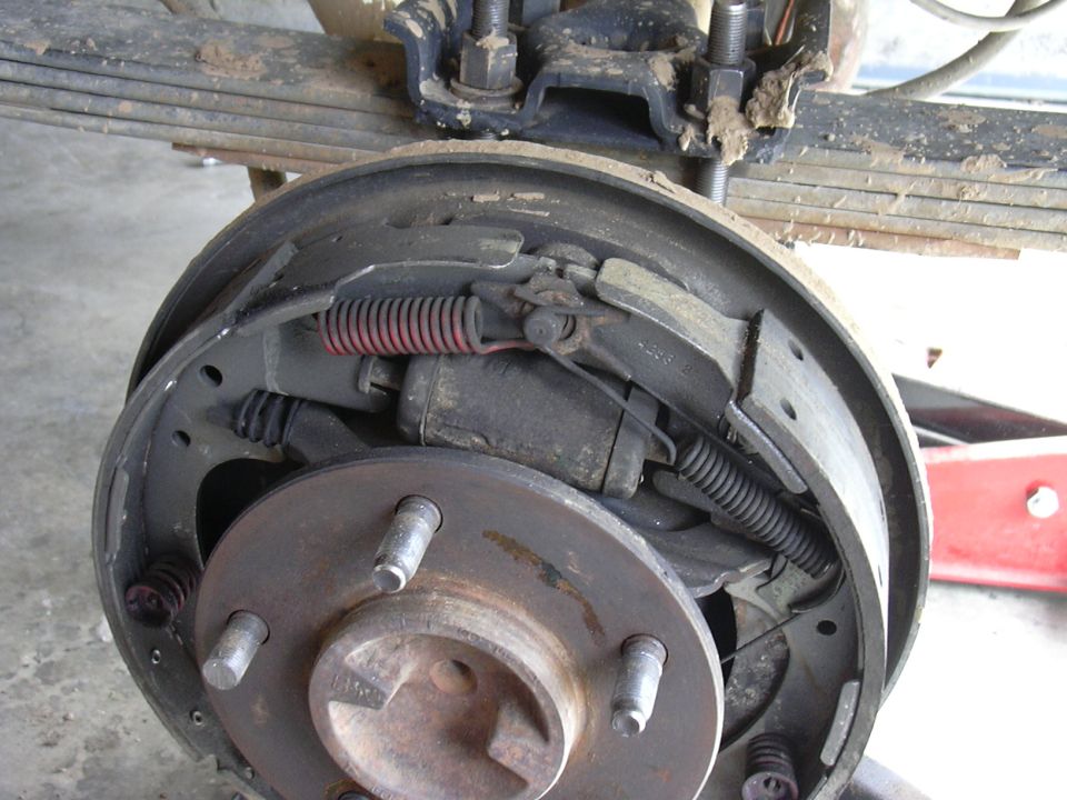 Rear drum brake assembly with brake shoes, springs, and wheel cylinder visible