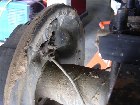 1991 Ford Bronco - This photo shows a close-up view of a vehicle's brake assembly, covered in dirt and grime.