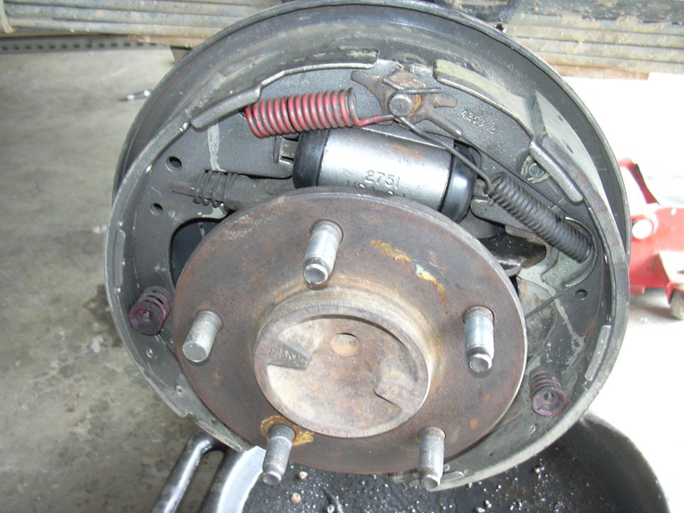Close-up of a drum brake assembly with brake shoes, wheel cylinder, and rotor visible