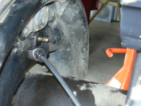 1991 Ford Bronco - Detail of a vehicle's brake system, focusing on the brake line and caliper attachment points.