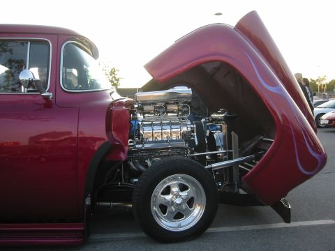 1992 Ford Crown Victoria - A custom hot rod with its hood open reveals a powerful supercharged engine and decorative flames.