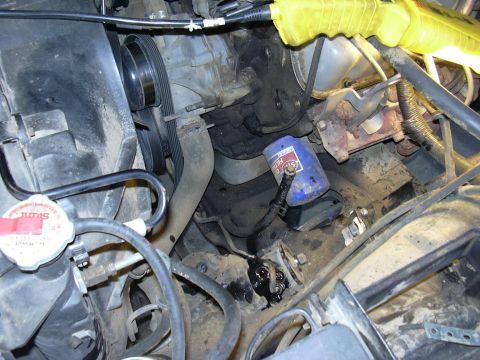 1991 Ford Bronco - Close-up view of an engine bay, a blue oil filter and various hoses and belts.