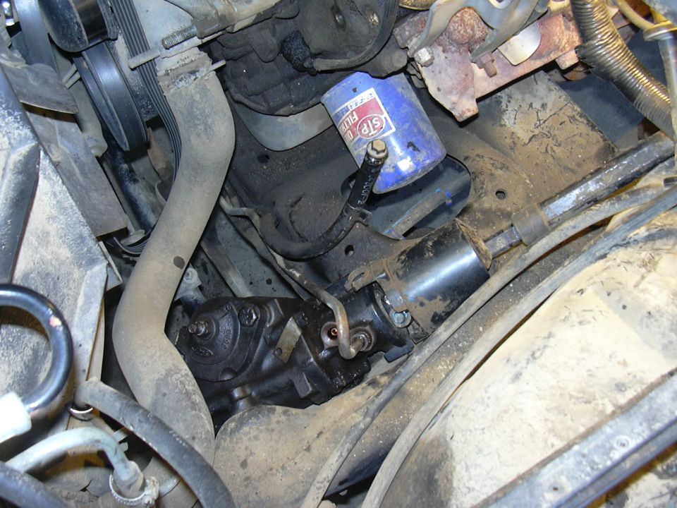 Steering gear box and oil filter in a vehicle engine bay