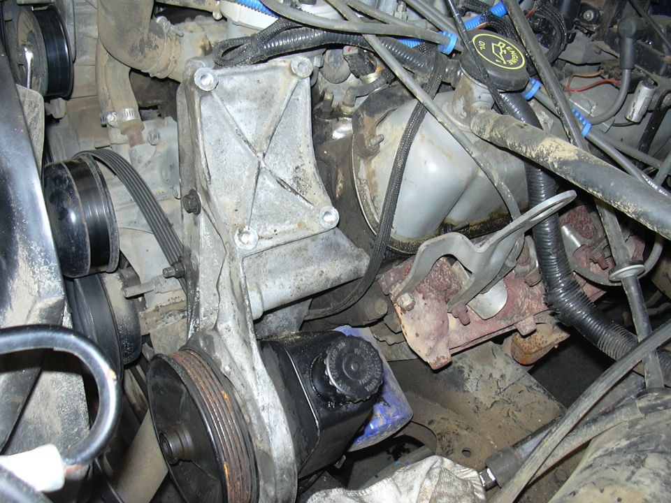 Engine bay of a 1991 Ford Bronco showing the power steering pump and pulley system