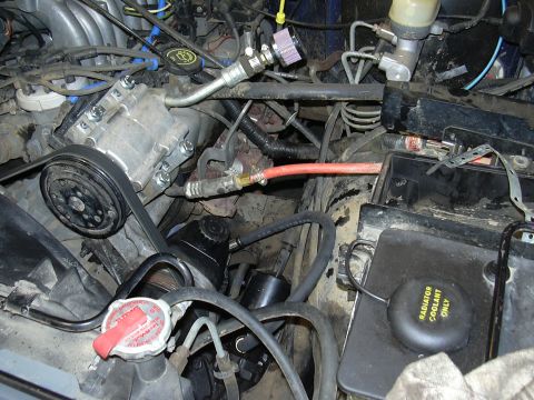 1991 Ford Bronco - Close-up view of engine components including the AC compressor and power steering pump.