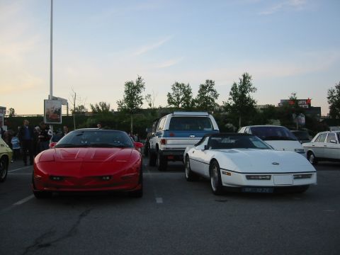 1992 Ford Crown Victoria - Several cars are parked in a lot during an outdoor event.