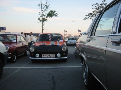 1992 Ford Crown Victoria - A customized orange and black Mini Cooper is parked in a lot with other vehicles.