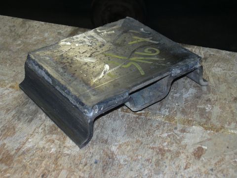 1991 Ford Bronco - A fabricated metal bracket or mount made from welded steel plate and channel/angle stock, with yellow paint-marker markings on top, sitting…