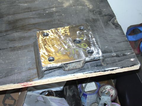 1991 Ford Bronco - A freshly fabricated steel mounting plate with multiple drilled bolt holes, welded to angled bracket sections, showing bright ground/polish…