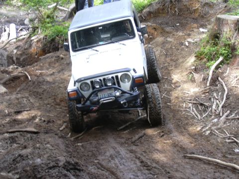 1991 Ford Bronco - This Jeep is navigating a challenging, muddy off-road trail.