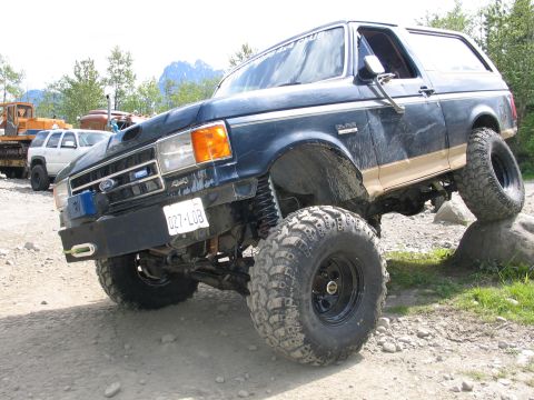 1991 Ford Bronco - This modified Ford Bronco is navigating a rocky trail, demonstrating its off-road capabilities.