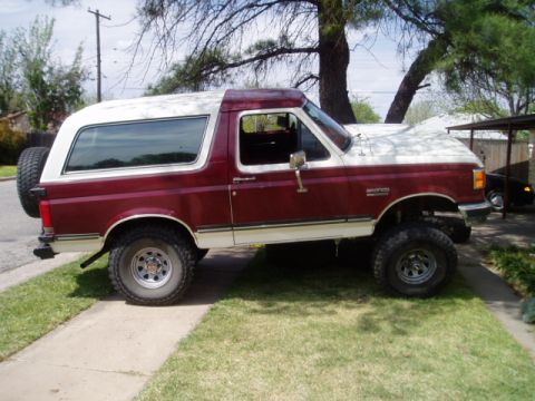1990 Ford Bronco - This 1990 Ford Bronco features a two-tone maroon and white paint scheme and a spare tire mounted on the rear.
