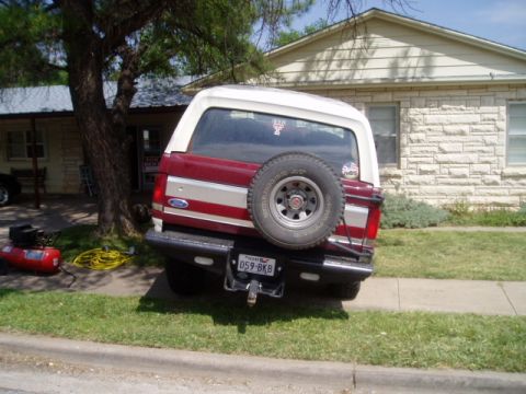 1990 Ford Bronco - Rear view of a 1990 Ford Bronco, showing the spare tire and license plate.