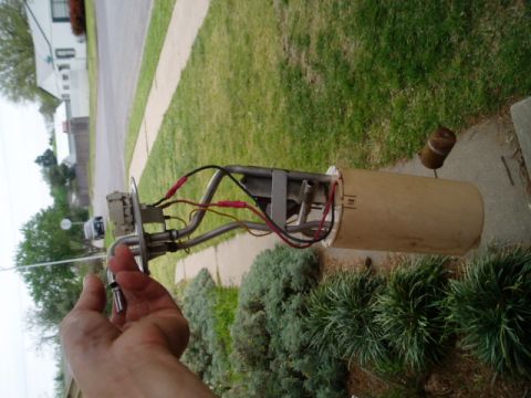 1990 Ford Bronco - A fuel pump assembly, likely for an older vehicle, is shown with its components and a wooden casing.