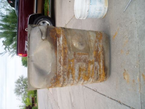 1990 Ford Bronco - A heavily rusted fuel tank is shown, likely removed from a vehicle for repair or replacement.