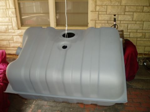 1990 Ford Bronco - A gray plastic fuel tank is shown from a side angle, suspended by a white string.