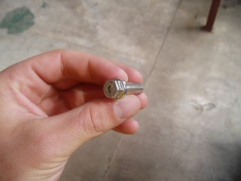 1990 Ford Bronco - A single hex head bolt is held in a person's hand.