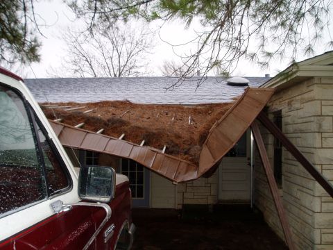 1990 Ford Bronco - A truck is parked near a house where a section of the roof has fallen in.