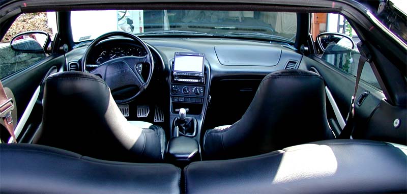 Interior view of black convertible with leather seats and aftermarket stereo