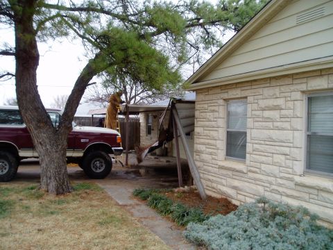1990 Ford Bronco - A 1990 Ford Bronco is parked outside a house while a person works on the roof.