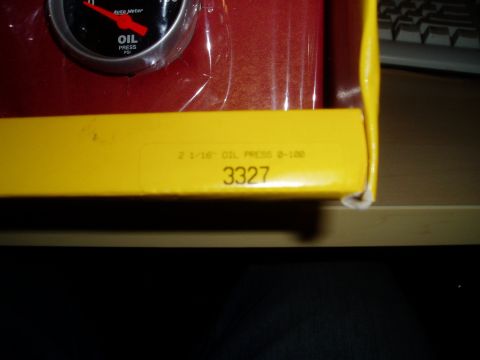 1990 Ford Bronco - Close-up of an oil pressure gauge, likely new in its packaging, with identifying text and numbers.