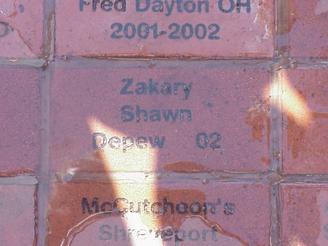 Engraved red memorial bricks with names Fred Dayton OH, Zakary Shawn Depew, and McCutcheon's Shreveport